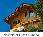 Alpine Swiss Village. Comfort and tranquility. A sunny summer day. Flowers on the windows. Wooden chalets.