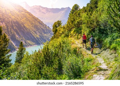 Alpine track and two hikers at mountain lake - Shutterstock ID 2165286595