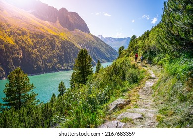 Alpine track and two hikers at mountain lake - Shutterstock ID 2167683359