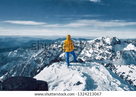 Alpinist standing at snow covered top of the peak of Jebel Toubkal in Atlas mountains Morocco