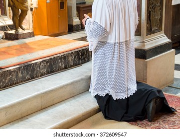 An altar boy or a mass servant kneeling during the extraordinary traditional form of the Catholic latin mass.