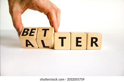 Alter or better symbol. Businessman turns wooden cubes and changes the word 'alter' to 'better'. Beautiful white background, copy space. Business and alter or better concept.