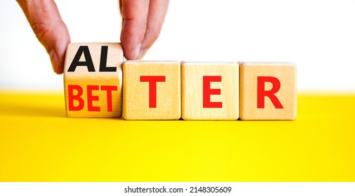 Alter or better symbol. Businessman turns wooden cubes and changes the word Alter to Better. Beautiful yellow table, white background, copy space. Business and alter or better concept.