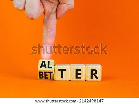 Alter or better symbol. Businessman turns wooden cubes and changes the word Alter to Better. Beautiful orange table, orange background, copy space. Business and alter or better concept.