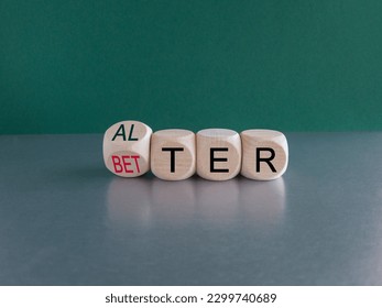Alter or better symbol. Turned wooden cubes and changed the word Alter to Better. Beautiful grey table, green background, copy space. Business and alter or better concept.