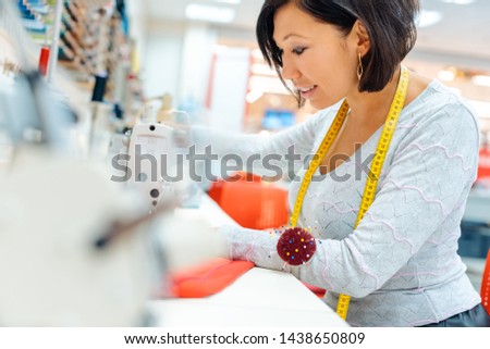 Alterations tailor in her studio working in some clothes with sewing machine
