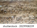 Alternation of layers of sand and gravel in a sediment near the coast