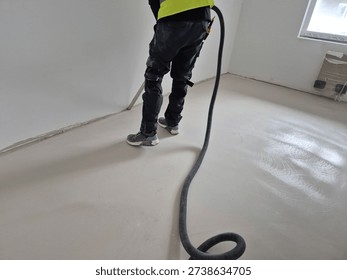 Alternative angle of professional post-construction cleaning with an industrial vacuum cleaner in a renovated room.
