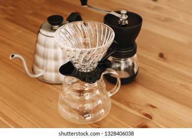 Alternative coffee brewing method. Stylish accessories and items for alternative coffee on wooden table. Glass flask with dropper, kettle, grinder for pour-over coffee with a filter dripper - Shutterstock ID 1328406038