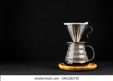 Alternative coffee brewing method,pure over,glass teapot on wooden tray with freshly brewed coffee on dark background. - Shutterstock ID 1441282733