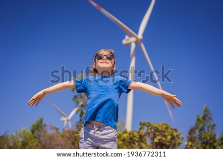 Alternative energy, wind farm and happy time with your family. Happy boy on vacation and escape to nature