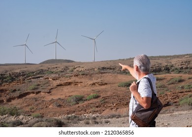 Alternative Energy, Wind Farm On The Mountain In Tenerife. Back View Of Mature Man Looking At  Wind Turbines Farm. Concept Of Renewable Energy, Love Of Nature, Clean, Green Electricity, Future.