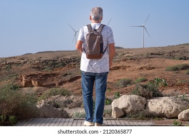 Alternative Energy, Wind Farm On The Mountain In Tenerife. Back View Of Mature Man Looking At  Wind Turbines Farm. Concept Of Renewable Energy, Love Of Nature, Clean, Green Electricity, Future.