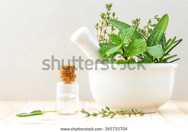 Alternative health care fresh herbal\
and  Bottle of aromatherapy in mortar on wooden\
background.