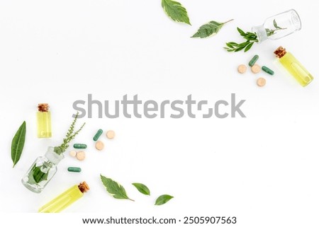 Alternative herbal medicine concept with healing herbs and essential oil in glass bottles.