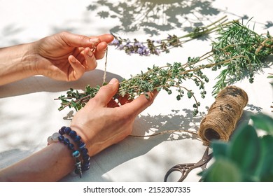 Alternative medicine. Collection and drying of herbs. Woman holding in her hands a bunch of marjoram. Herbalist woman preparing fresh scented organic herbs for natural herbal methods of treatment. - Shutterstock ID 2152307335