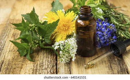 Alternative medicine with plant-based essential oil bottle and medicinal plants
