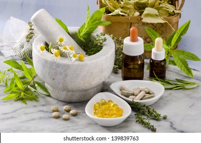 Alternative Medicine. Rosemary, mint, chamomille, thyme in a marble mortar. Essential oils and herbal supplements.