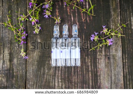 Alternative Medicine.Thyme and medical ampoules on a wooden rustic background. Essential oils and herbal supplements.