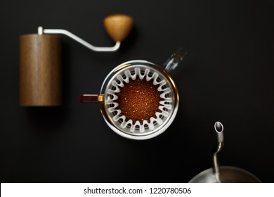 alternative method of brewing coffee. Filter with ground coffee in the funnel in focus. Left coffee grinder right teapot blurred - Powered by Shutterstock