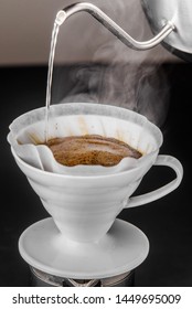 Alternative method of making coffee. coffeemaker is a manual pour-over style glass. Cofee brewing on black background