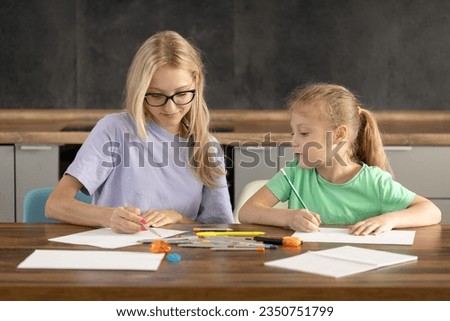 Alternative Pedagogy. A young woman teacher is engaged in individual lessons with a toddler girl. Online classes through a laptop, online lessons at distance home learning.  creative skills in a child