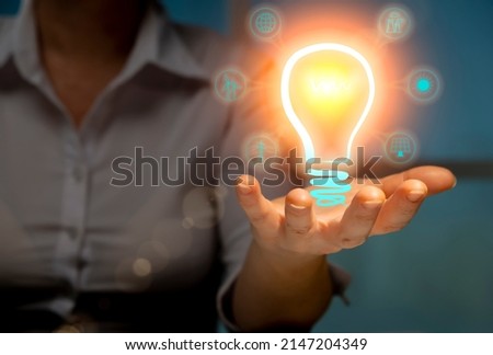 Alternative renewable power sources concept, woman engineer holding Illuminated virtual light bulb with green energy icons in hand