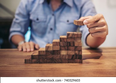 Alternative risk concept, plan and strategy in business, Risk To Make Business Growth Concept With Wooden Blocks, hand of man has piling up and stacking a wooden block.
