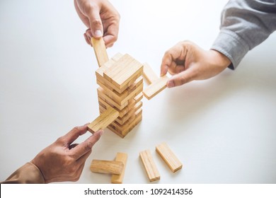 Alternative risk plan and strategy in business, Young intelligent business team playing the wood game, hands of executive cooperation placing wood block on the tower, Collaborative management.