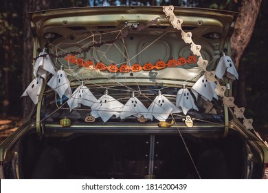 Alternative Safe Celebration. Cute Kids Preparing Halloween Party In The Trunk Of Car With Carved Pumpkin, Spider Net, Ghosts And Other Decoration For Halloween, Autumn Outdoor.