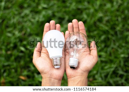 Alternative technology concept . Hands holding LED Bulb and Fluorescent bulb comparing in hands . copy space for text . 商業照片 © 
