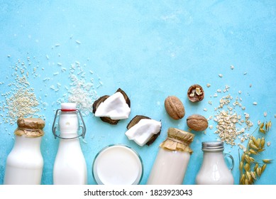 Alternative types of vegan milks in glass bottles on a light blue slate, stone or concrete background. Top view with copy space. - Shutterstock ID 1823923043