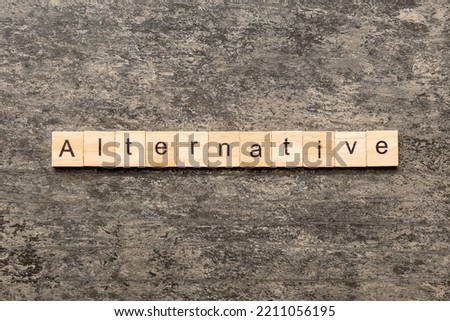 alternative word written on wood block. alternative text on table, concept.