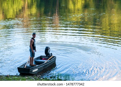 Althom, Pennsylvania, USA 8/10/2019 A Man Standing On A Boat On The Shore Of The Allegheny River In Warren County In Summertime