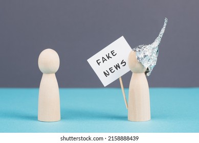 Alu Hats Protester Talking To A Person, Conspiracy Theories, Tin Foil On The Head, Holding A Sign With Fake News, Conversation And Communication Concept