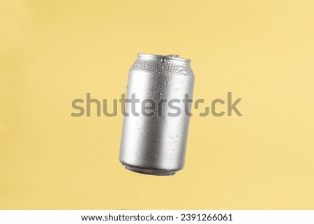 Aluminium beer or soda drinking can on light yellow background