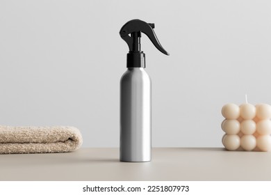 Aluminium cosmetic trigger sprayer bottle  mockup with a candle and a towel on the beige table. - Shutterstock ID 2251807973