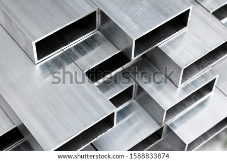 Aluminium profile for windows and doors manufacturing. Structural metal aluminium shapes. Aluminium profiles texture for constructions. Aluminium constructions factory background.