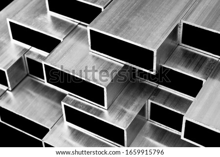 Aluminium profile for windows and doors manufacturing. Structural metal aluminium shapes. Aluminium profiles texture. Aluminium constructions factory. Black and white