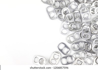 Aluminium Ring Pull Opener Or Ring Tabs On White Background, Free Space For Text In Middle. Concept : Recycle Ringpulls For Disable Prostheses.