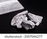 aluminum ingot or bar next to aluminum ore, recycling or metal industry concept