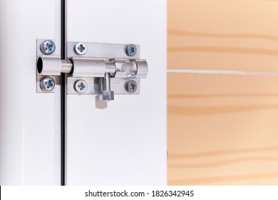 Aluminum manual latch bolt installed on a white lacquered aluminum carpentry door inside a home