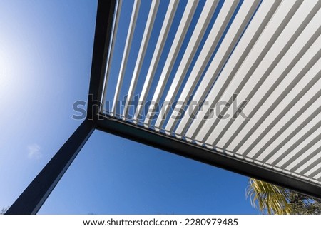 Aluminum pergola for outdoor patio against clear blue sky. Bottom view