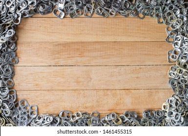 aluminum pull tabs on wooden table to recicle,copy space for text.