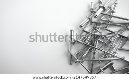 Aluminum rivets on a white background. Sale of rivets and fixing tools.