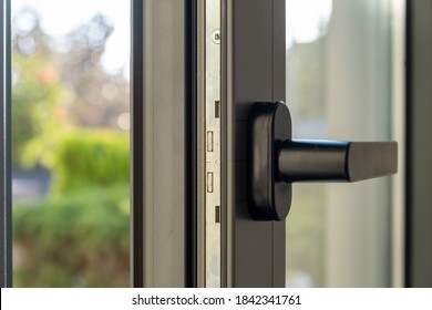 Aluminum Window Detail. Metal Door Frame Open Closeup View. Energy Efficient, Safety Profile, Blur Green Outdoor Background