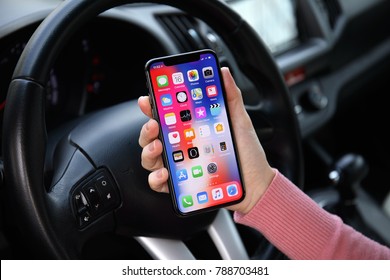 Alushta, Russia - December 16, 2017: Woman hand holding iPhone X with IOS 11 on the screen in the car. iPhone 10 was created and developed by the Apple inc.