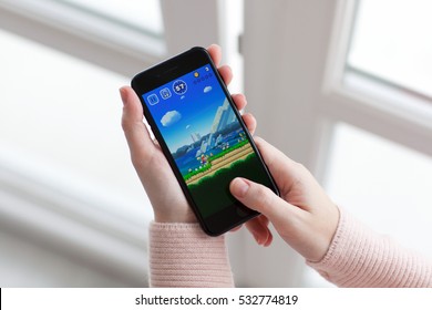 Alushta, Russia - November 19, 2016: Woman Hand Holding IPhone 7 Jet Black With Game Super Mario Run In The Screen. Games Super Mario Run Was Created And Developed By The Nintendo.