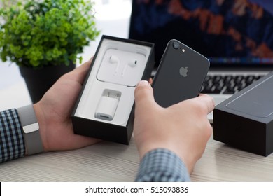 Alushta, Russia - November 2, 2016: Man Unboxing New IPhone 7 Over MacBook Pro. IPhone 7 Jet Black And Macbook Was Created And Developed By The Apple Inc.