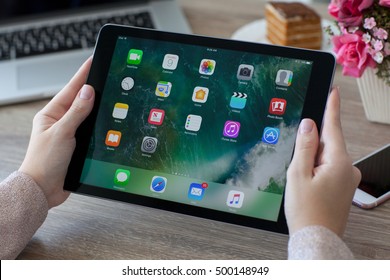 Alushta, Russia - October 9, 2016: Woman Holding In The Hand A IPad Pro Space Gray With Wallpaper IOS 10 In The Screen. IPad Pro Was Created And Developed By The Apple Inc.